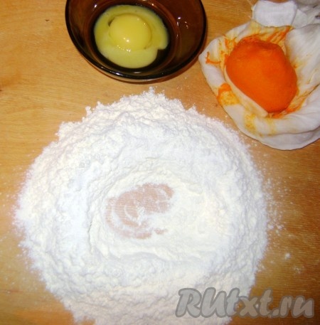 Муку просеять на стол, сделать углубление, добавить соль, растительное масло, желтки и тыквенное пюре.