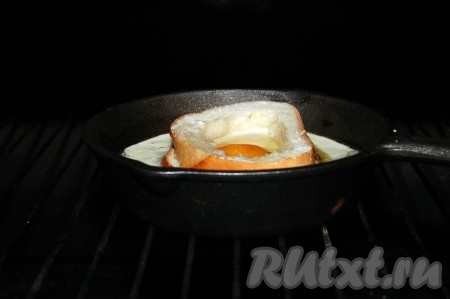 Внутрь кольца из хлеба разбить яйцо, стараясь сохранить желток целым, посолить. Отправить нашу порционную форму с яичницей в хлебе в заранее нагретую до 200 градусов духовку.
