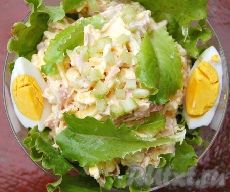 В вазочку, застеленную листьями салата, выложить салат из ветчины, сыра и яиц. Украсить половинкой яйца, разрезанной на дольки, и зеленью. Этот салат готовится из минимального набора ингредиентов, а его нежный, мягкий вкус несомненно понравится и вам, и вашим близким!