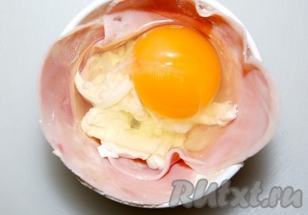 Яйцо разбиваем на сыр. Солим, стараясь, чтобы соль не попала на желток (иначе останутся вмятины).