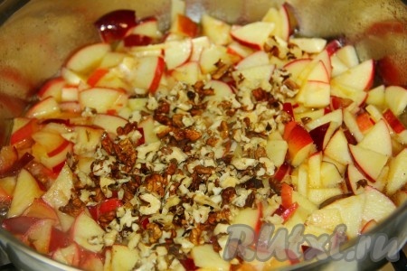 Через пару минут к яблокам отправляем измельченные орехи. Тушим под крышкой до тех пор, пока яблоки не станут мягкими.