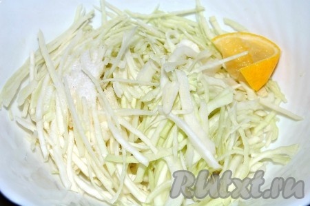 Наструганную капусту сложить в миску, добавить соль и выжать сок из лимона.