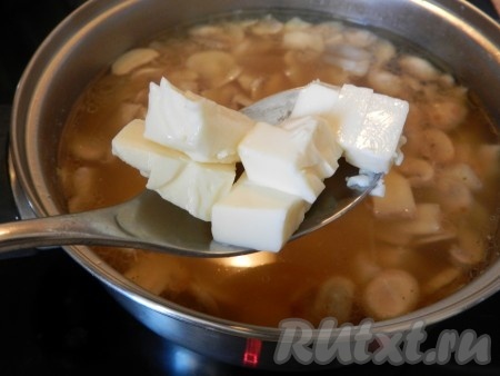Затем добавить в суп обжаренные шампиньоны с луком, нарезанное куриное мясо, дать закипеть, а после этого варить ещё 3 минуты на умеренном огне. Плавленный сыр нарезать на кусочки (или натереть на тёрке) и опустить его в суп (можно использовать и мягкий плавленный сыр, специально предназначенный для супов), перемешивая, чтобы сыр полностью растворился.