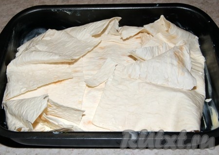 Выложить оставшиеся листы лаваша, нарезанные на кусочки. Накрыть свисающими листами лаваша, чтобы получился закрытый со всех сторон пирог.