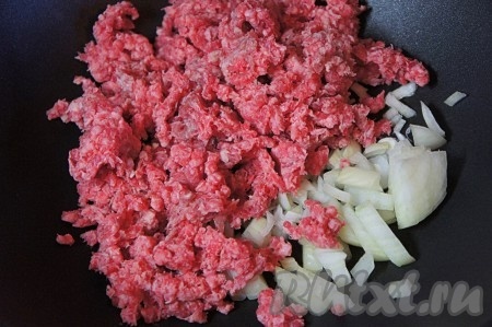 Перекрутить кусочек мякоти говядины на мясорубке. На сковороду влить немного растительного масла, выложить перекрученный фарш, добавить очищенный и мелко нарезанный репчатый лук.