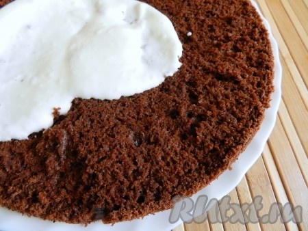 Промазать сметанным кремом один бисквитный корж, накрыть вторым и обмазать кремом весь шоколадный торт.
