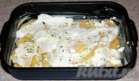 Слой картофеля обильно полить сметаной, посыпать немного специями и солью.