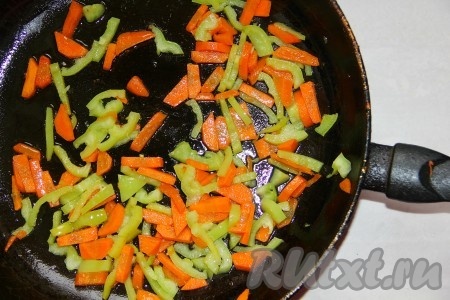  К моркови добавляем сладкий перец и тушим овощи 5 минут на среднем огне.