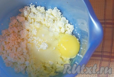 Творог размять вилкой, добавить сахарный песок и 1 яйцо (другое оставим для смазывания булочек перед выпечкой). Перемешать.

