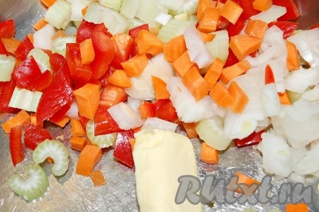 Морковь и сладкий перец нарежем кубиками, сельдерей небольшими кусочками и выложим овощи в кастрюлю со сливочным маслом. Нужно медленно обжаривать, часто помешивая, чтобы ничего не пригорело.