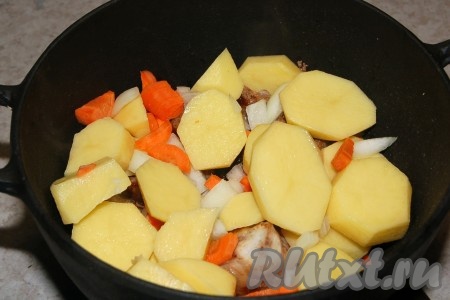 В жаровню уложить на дно обжаренные кусочки говяжьей грудинки, а сверху разместить картофель с морковью и репчатым луком.