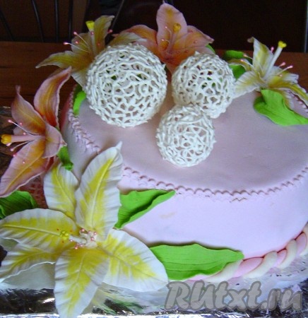 Я обтянула торт мастикой из маршмеллоу (собственного изготовления), шарами из айсинга и мастичными цветами.
