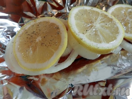 Отрезать 2 листа фольги. На каждый лист фольги выложить кусочек лосося. Поверх рыбы разложить кольца лука и лимона, можно немного (по вкусу) посолить и поперчить. Завернуть каждый кусок лосося с лимоном и луком плотно в фольгу.