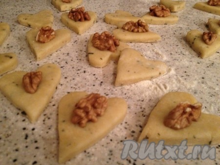 Далее раскатываем охлажденное тесто в пласт толщиной 0,5 см, вырезаем печенье с розмарином формочками (у меня сердечки) и украшаем грецкими орехами.
