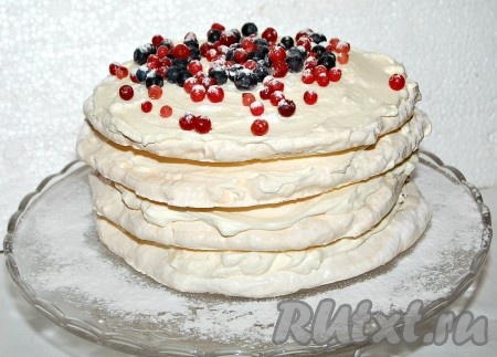 Верхний корж торта "Безе" также смазать кремом и обсыпать ягодами и сахарной пудрой.
