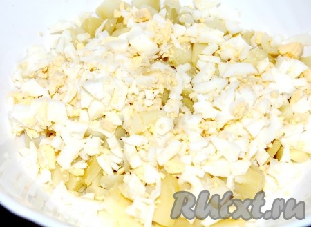 Яйца мелко нарезать и выложить в салатник с картошкой.
