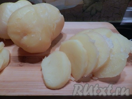 Остудить варёный картофель, очистить и нарезать кружочками. Сыр натереть на крупной тёрке.
