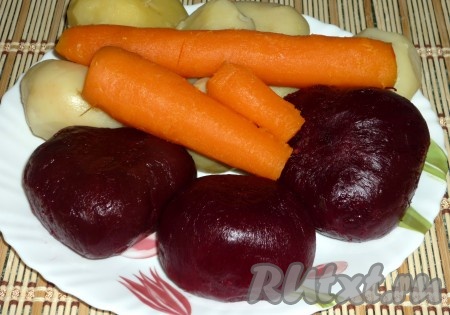 Картофель, свеклу, морковь хорошо вымыть. Овощи сложить в кастрюлю, залить водой, довести до кипения и отварить до готовности.
Отваренные овощи очистить от кожуры.
