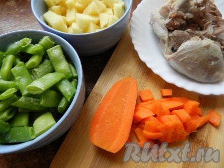 Когда мясо индейки сварится, достать его из бульона, также достать луковицу и морковь. Лук выкинуть. Морковь нарезать кубиками, мясо нарезать кусочками. Бульон процедить, довести до кипения, добавить в него очищенный и нарезанный на небольшие кубики картофель, кусочки индейки и нарезанную варёную морковь, посолить, поперчить и варить с момента закипания 7-8 минут на небольшом огне. Если стручковая фасоль свежая, отрежьте "хвостики" с двух сторон, а затем разрежьте каждый стручок на 2-3 части. Если фасоль заморожена, размораживать её предварительно не нужно.
