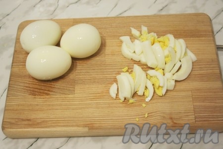 Отварите яйца вкрутую. Очистите. 2 яйца и 2 желтка нарежьте соломкой, а 2 белка оставьте для украшения салата.
