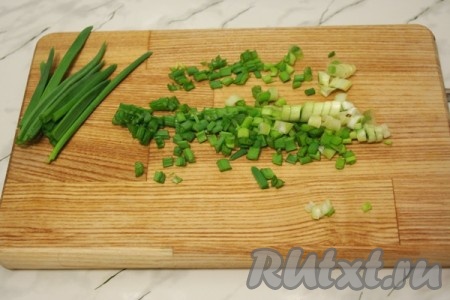 Зелёный лук помойте, обсушите и нарежьте. Оставьте зеленые кончики лука для украшения салата.