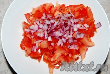 Лук репчатый мелко нарезать и добавить к помидорам.