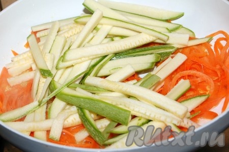 Морковь очистить и обмыть. Налить растительное масло в сковороду и выложить в неё морковь, нарезанную тонкой соломкой. Кабачки также нарезать тонкой соломкой (я готовила кабачок, не очищая от кожуры) и добавить к моркови. Обжарить овощи на среднем огне, примерно, 5-7 минут.