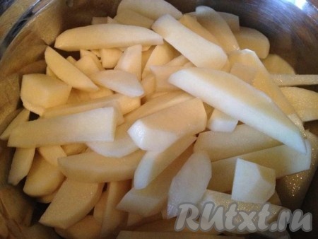 Затем нарезаем ломтиками картошку, кладем её в большую миску.