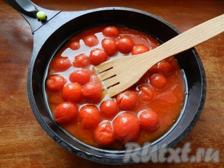В ароматное масло вылить помидоры в собственном соку из банки и потушить их 10 минут, постоянно помешивая.
