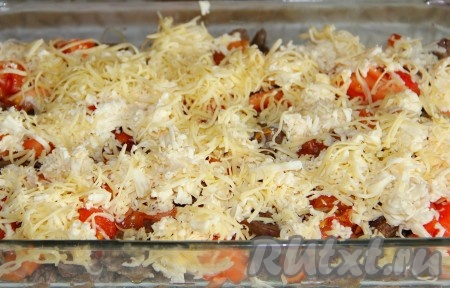 Сыр натираем на крупной тёрке и равномерно раскладываем его поверх помидоров и печёнки.