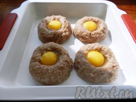 В середину каждого гнезда поместить по одному сырому куриному яйцу. Чтобы яйцо не вытекло, добавьте сначала желток, а оставшееся место заполните белком. Яйцо сверху посолить и поперчить. Запекать мясные гнезда в разогретой до 190 градусов духовке 30-35 минут. Чтобы желток при запекании не засох, мясные гнезда можно прикрыть фольгой.
