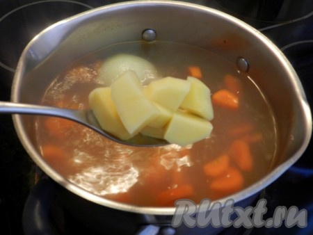 В бульон с морковью выложить картофель, нарезанный кубиками, дать закипеть, а затем варить суп на небольшом огне до готовности картошки (минут 15-20 - время варки зависит от сорта картофеля и величины нарезки).
