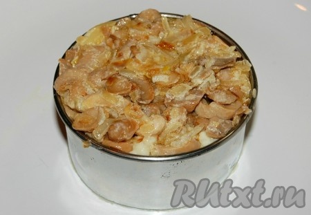 Поверх картофельного пюре уложить слой жареных шампиньонов. Грибы тоже утрамбовать с помощью ложки.

