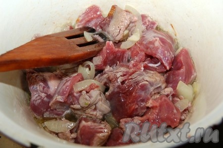 Мясо нарезать небольшими кусочками, добавить в латку, обжаривать с луком вместе 15 минут.
