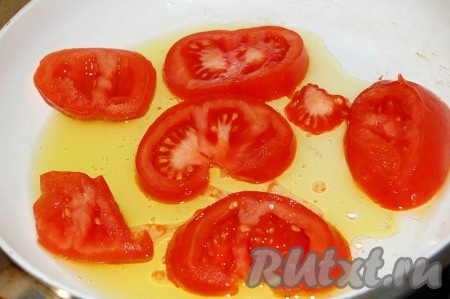 На эту же сковороду добавить масло и выложить для обжарки нарезанные кружочки помидоров.