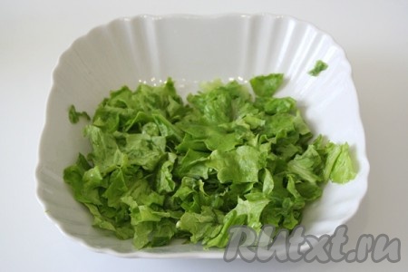Листья салата помыть, обсушить и порвать руками. Положить листья в салатницу. 