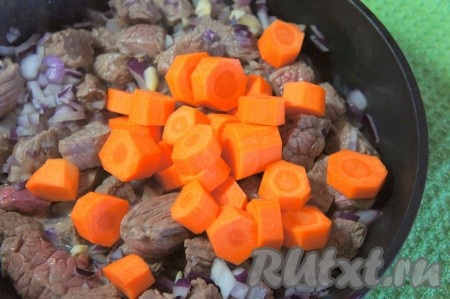 Морковь крупно нарезать, добавить к мясу, перемешать, готовить ещё 5-7 минут.