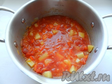 Затем добавить помидоры из банки, чеснок, пропущенный через пресс, специи и посолить, если нужно. Долить воды до двух литров и варить 10 минут.