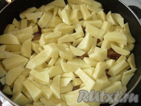 Очищенный картофель режем кусочками и  добавляем  к мясу, тушим  ещё минут 10. 