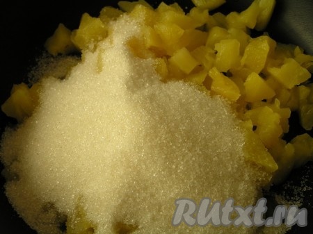 А пока приготовить ананасовый джем. Консервированные ананасы откинуть на дуршлаг, чтобы слить лишнюю жидкость, затем нарезать на небольшие кусочки и выложить в сковороду с антипригарным покрытием и поставить на огонь. Всыпать сахар, перемешать.