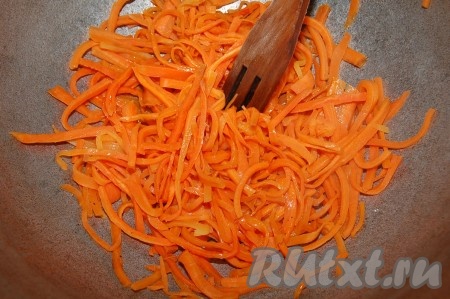 Растительное масло раскалить в казане и в раскаленное масло разместить нашинкованную длинной соломкой морковь. Обжаривать морковь 7 минут.
