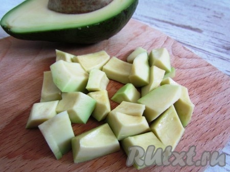 Авокадо очистить от кожуры, разрезать вдоль, удалить косточку и нарезать кубиками.