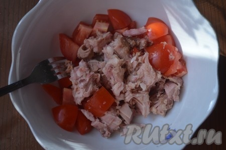 Добавить к помидорам консервированный тунец (жидкость сохранить), слегка размять его вилкой.
