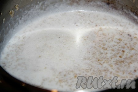 В кипящее молоко добавить овсяные хлопья и сахар. Перемешать, оставить вариться на пару минут на плите.
