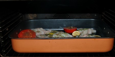 Отправить противень (форму) с зубаткой и помидорами в заранее нагретую до 200 градусов духовку на 30 минут.