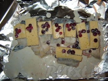 Присолите кусочки горбуши и положите на фольгу, сверху выкладываем сыр и ягоды.
