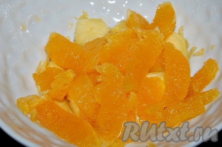 Вырезанные апельсиновые дольки добавить в миску к ананасам и тоже присыпать сахаром (1 чайная ложка).
