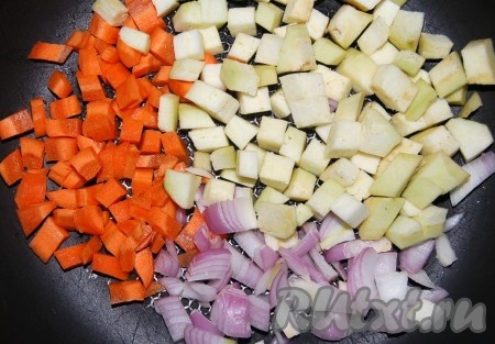 Нарезать некрупными кубиками морковь, репчатый лук и баклажаны. Налить в сковороду оставшееся растительное масло (2 столовые ложки) и на нем обжаривать овощи.

