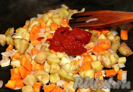 Когда овощи станут золотистыми и мягкими, добавить к ним томатную пасту. 