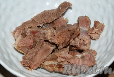 Через 2 часа вытащить баранину из кастрюли, нарезать мякоть небольшими кусочками, кости выкинуть. Мясо отправить обратно в кастрюлю.
